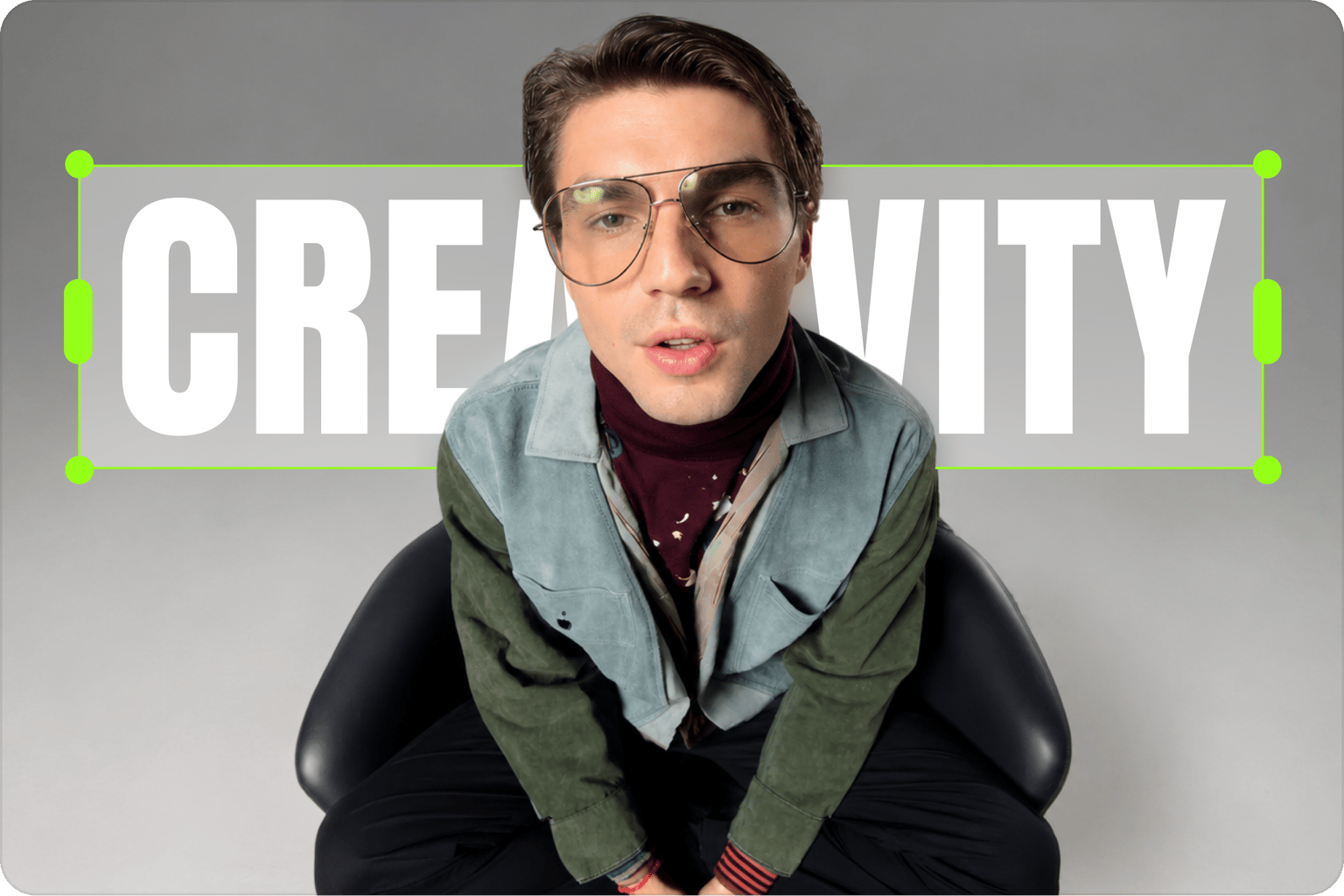 Video to photo tool showing a green editing box around the word creativity behind a seated man wearing glasses