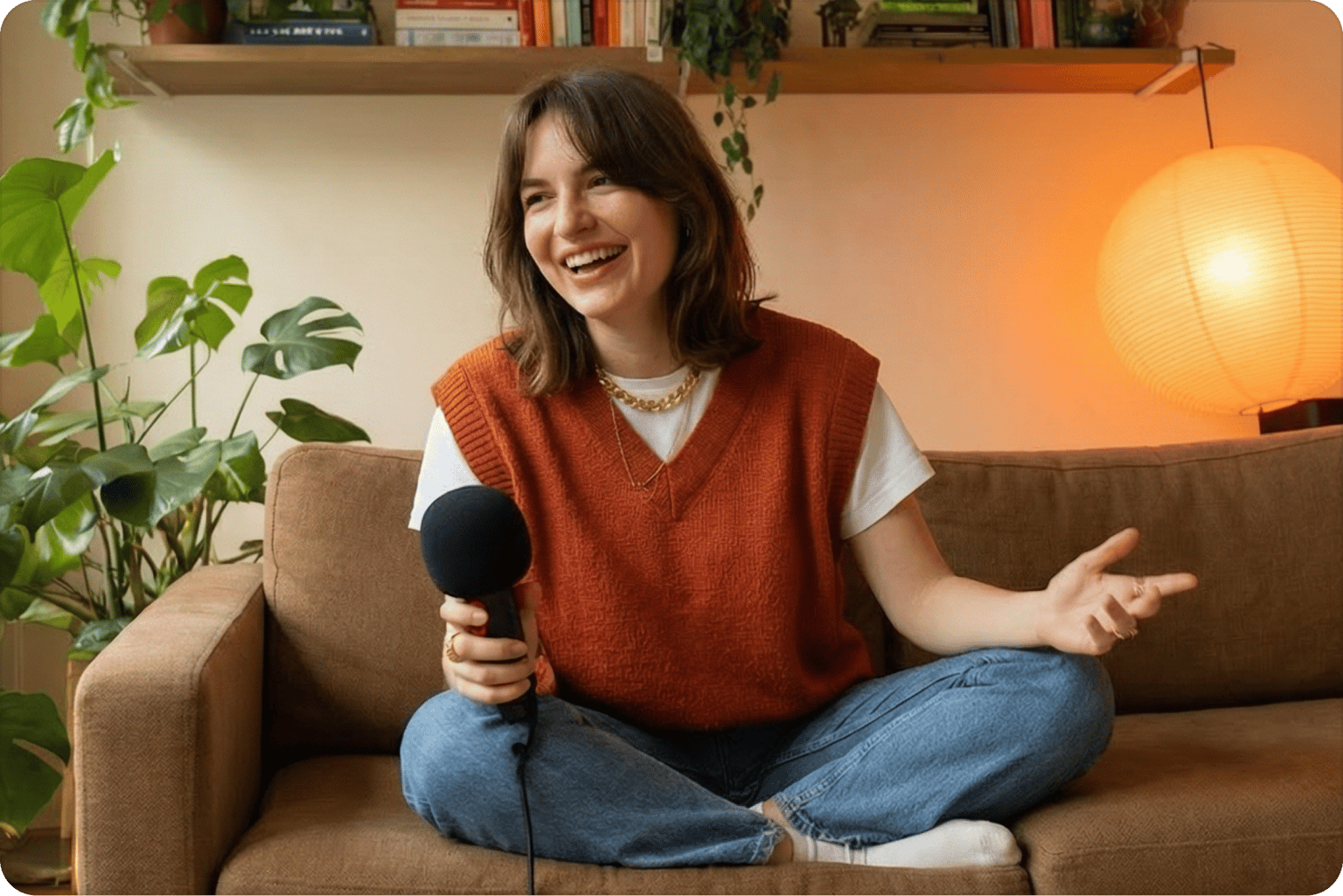 Free test your webcam preview showing a smiling woman sitting on a couch holding a black microphone