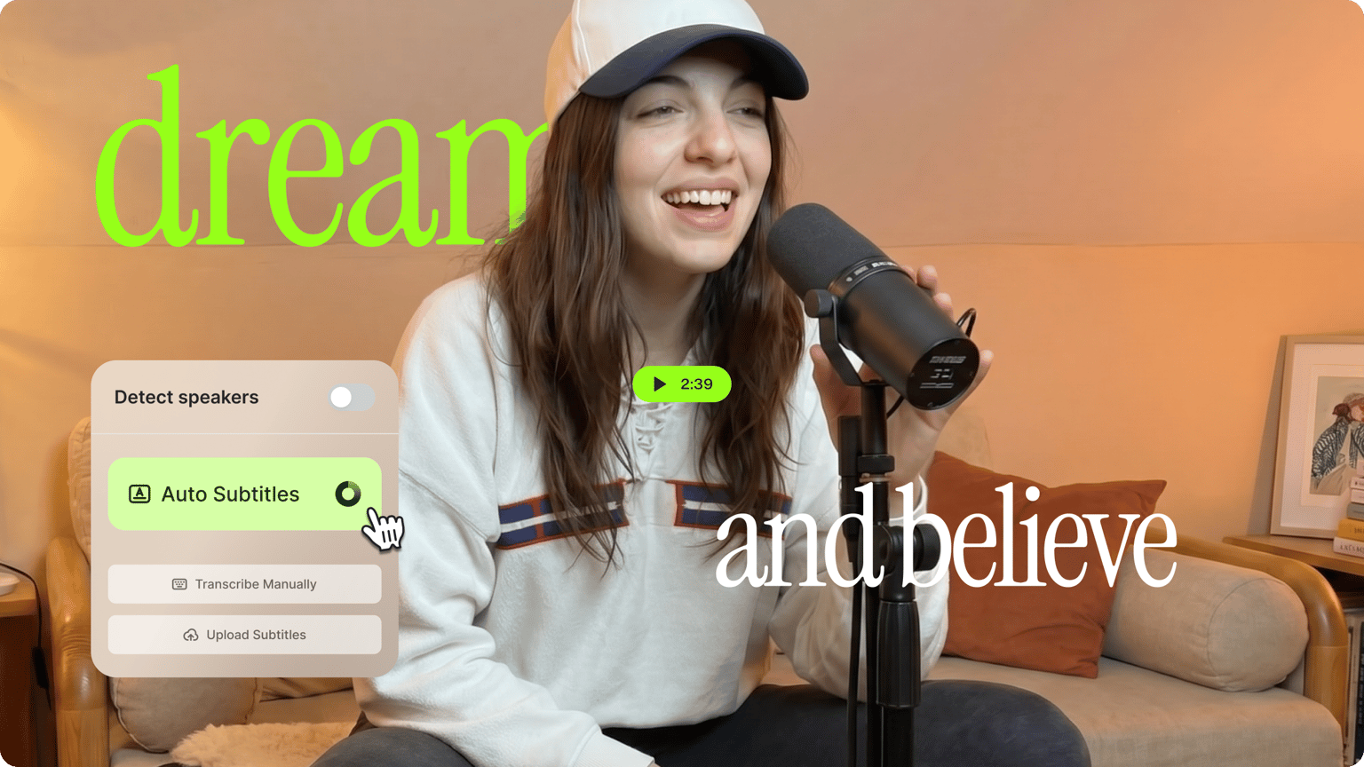 Woman singing into a microphone on a couch with big glowing neon words dream and believe auto subtitles.