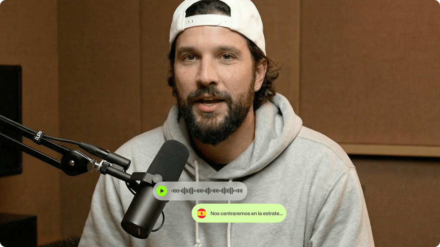 Man speaking into a studio microphone with an mp3 audio track overlay converting to Spanish text captions.
