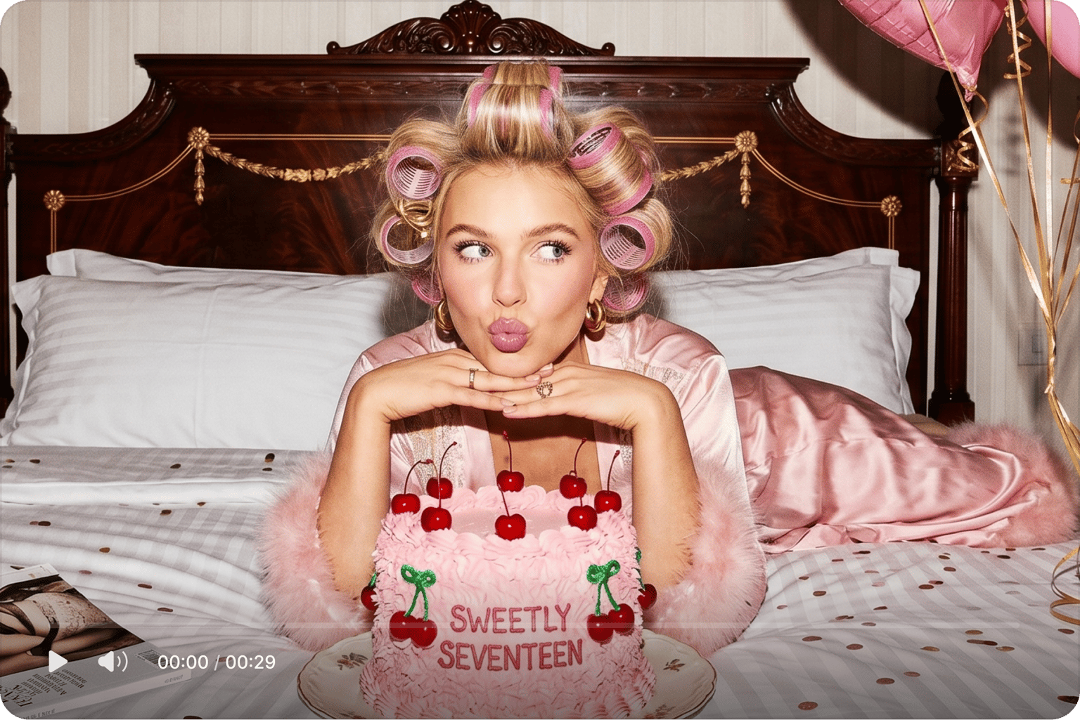 Birthday video maker showing a video of a woman in hair rollers on a bed with a sweetly seventeen pink cherry cake