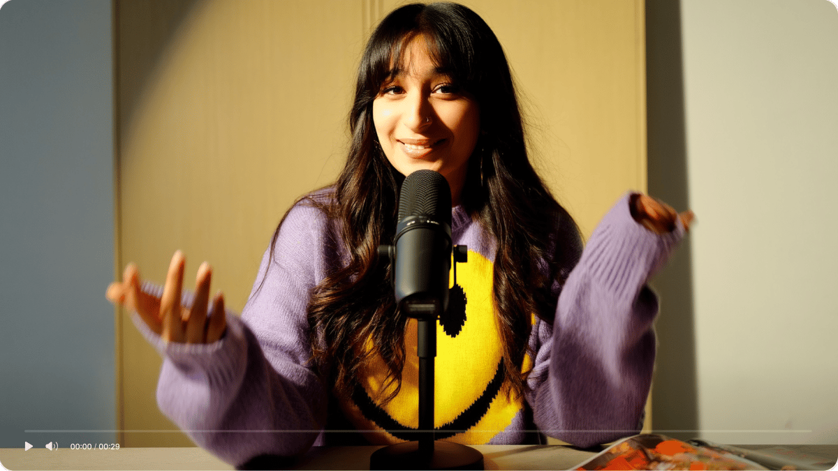 Video upload demo interface showing a smiling woman in a purple sweater gesturing in front of a microphone