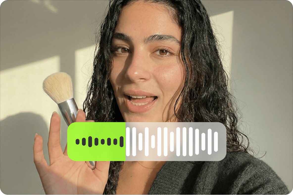 Woman holding a makeup brush with an active audio sound wave voice recording bar graphic over the video.
