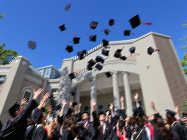 Blurry photo of graduates throwing their caps in the air